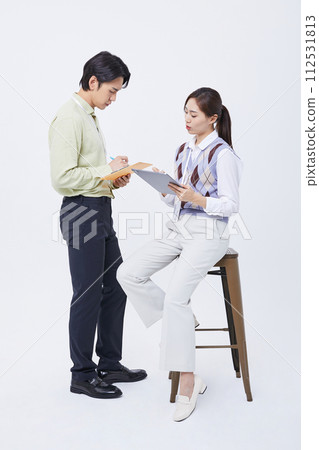 A man and a woman talking to a tablet while filing 112531813