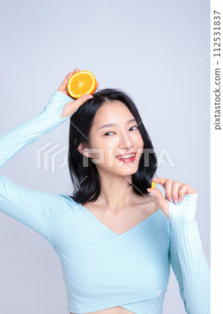 A woman holding a pill and an orange A woman holding a pill and an orange 112531837