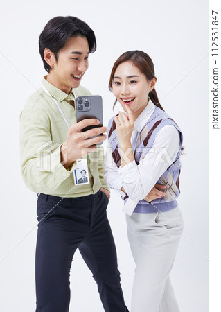 A man and woman smiling at a smartphone 112531847