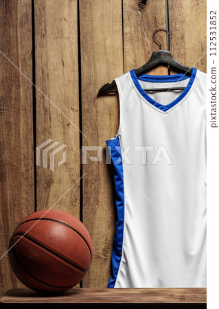 Basketball jersey on hanger against wooden background 112531852