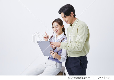 A man and woman smiling at a tablets 112531870