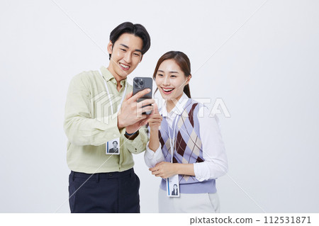 A man and woman smiling at a smartphone A man and woman smiling at a smartphone 112531871