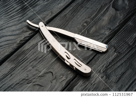 Sharp shaving razor on black wooden background Sharp shaving razor on black wooden background 112531967