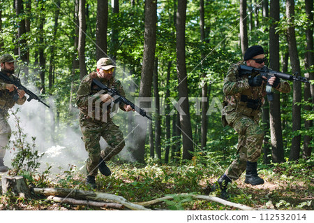 A specialized military antiterrorist unit conducts a covert operation in dense, hazardous woodland, demonstrating precision, discipline, and strategic readiness 112532014