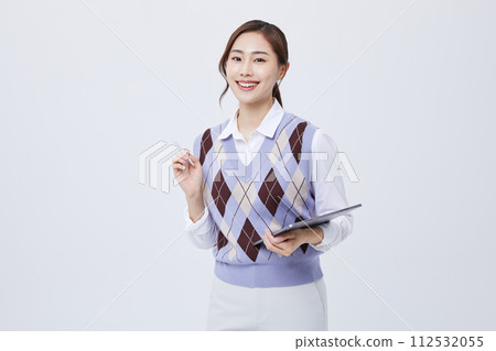 A photo of an office worker holding a tablet with his employee ID around his neck 112532055