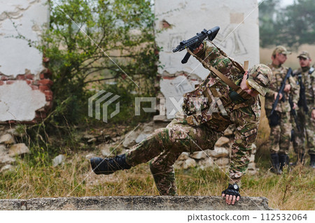 A highly trained elite military unit, clad in camouflage, skillfully navigates through perilous forest terrain, overcoming obstacles and executing a precise and covert mission A highly trained elite military unit, clad in camouflage, skillfully navigates through perilous forest terrain, overcoming obstacles and executing a precise and covert mission 112532064