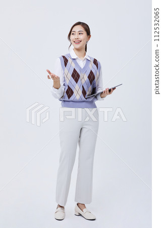 A photo of an office worker holding a tablet with his employee ID around his neck 112532065
