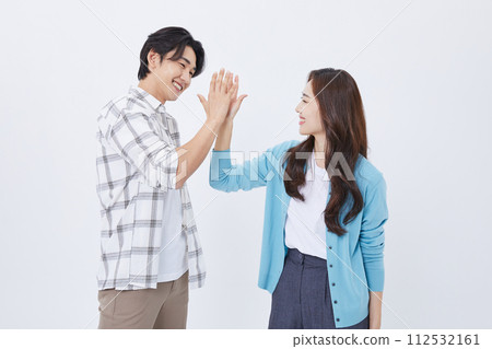 A man and a woman who high fives while preparing for a youth start up 112532161