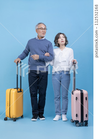A senior standing with a travel suitcase A senior standing with a travel suitcase 112532168