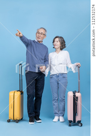 A senior standing with a travel suitcase 112532174
