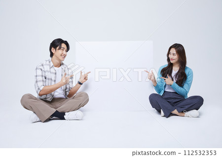 A man and a woman sitting next to an empty message sheet with two legs crossed A man and a woman sitting next to an empty message sheet with two legs crossed 112532353