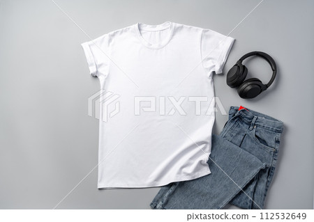 Cotton T-shirt and jeans on gray background top view Cotton T-shirt and jeans on gray background top view 112532649