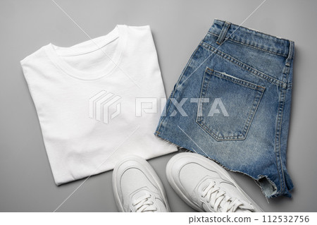 T-shirt, jeans and white sneakers on gray background top view T-shirt, jeans and white sneakers on gray background top view 112532756