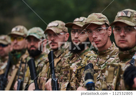 Soldier fighters standing together with guns. Group portrait of US army elite members, private military company servicemen, anti terrorist squad 112532805