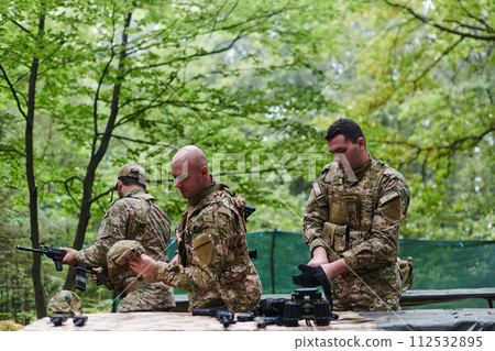 An elite military unit prepares for a hazardous forest operation, showcasing tactical prowess, camouflage skills, and strategic readiness 112532895