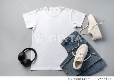 T-shirt, jeans and white sneakers on gray background top view 112533177