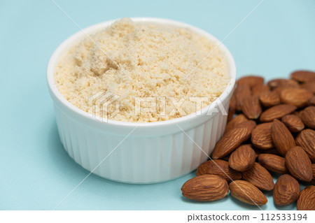 Almond flour and almonds on a light blue background 112533194