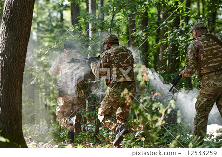 A specialized military antiterrorist unit conducts a covert operation in dense, hazardous woodland, demonstrating precision, discipline, and strategic readiness 112533259