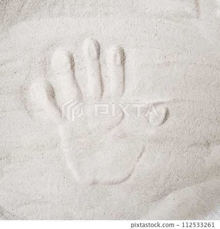A persons handprint on the sand top view A persons handprint on the sand top view 112533261