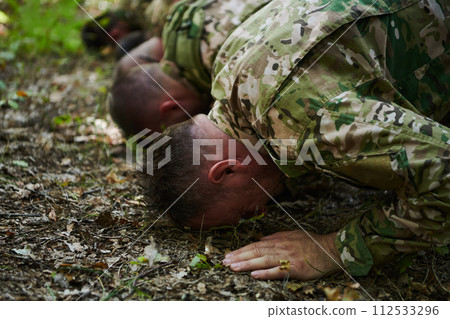 A dedicated group of soldiers engages in Islamic prayer amidst the challenging and perilous conditions of a military operation in dense forested areas A dedicated group of soldiers engages in Islamic prayer amidst the challenging and perilous conditions of a military operation in dense forested areas 112533296
