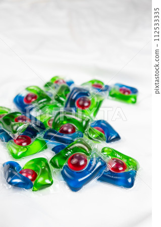 Lots of laundry pods on satin fabric close-up. 112533335