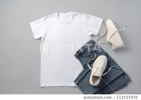 T-shirt, jeans and white sneakers on gray background top view 112533350