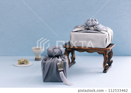 There is a gift cloth on the top and bottom of the tea table, and rice cakes and teacups are placed 112533462