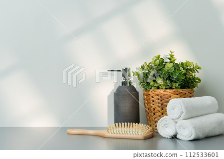 Soap dispenser and spa towels on white background in shadow Soap dispenser and spa towels on white background in shadow 112533601