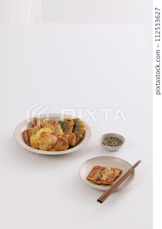 On two plates, there's a pancake with soy sauce and chopsticks On two plates, there's a pancake with soy sauce and chopsticks 112533627