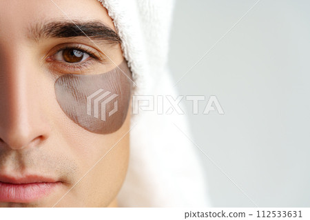 Portrait of attractive young male model with eye patches on white background Portrait of attractive young male model with eye patches on white background 112533631