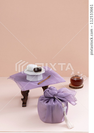 There is a rice cake on the tea table and a gift cloth and a water bottle of tea on the bottom There is a rice cake on the tea table and a gift cloth and a water bottle of tea on the bottom 112533661