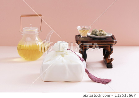 There is a plate of rice cake on the tea table, a wooden fork, a kettle, and a gift cloth There is a plate of rice cake on the tea table, a wooden fork, a kettle, and a gift cloth 112533667