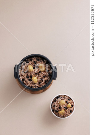 There is a bowl of five grain rice in a pot and a bowl of rice 112533672