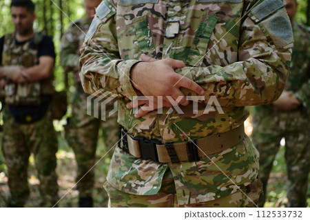 A dedicated group of soldiers engages in Islamic prayer amidst the challenging and perilous conditions of a military operation in dense forested areas 112533732