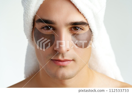 Portrait of attractive young male model with eye patches on white background 112533733
