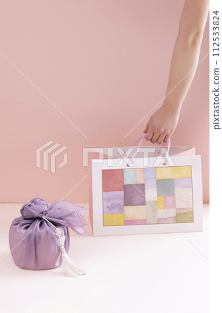 hold a traditional patterned shopping bag next to a gift cloth hold a traditional patterned shopping bag next to a gift cloth 112533824
