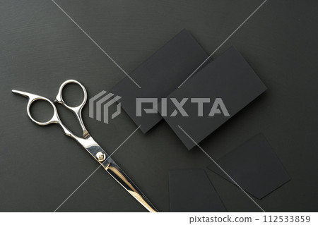 Hairdressing scissors and businesscard mock up on black background Hairdressing scissors and businesscard mock up on black background 112533859