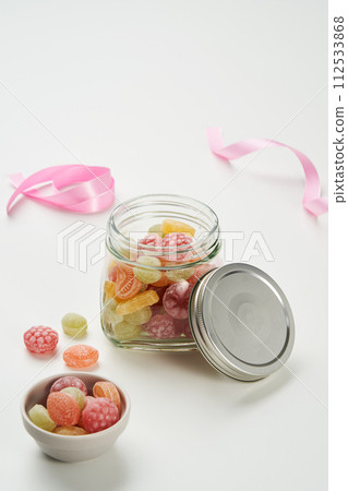 The fruit shaped candy is filled in a glass jar and on a plate 112533868