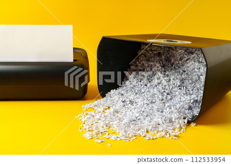 Office paper shredder on yellow studio background Office paper shredder on yellow studio background 112533954