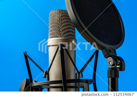Professional microphone stand over blue studio background 112534067