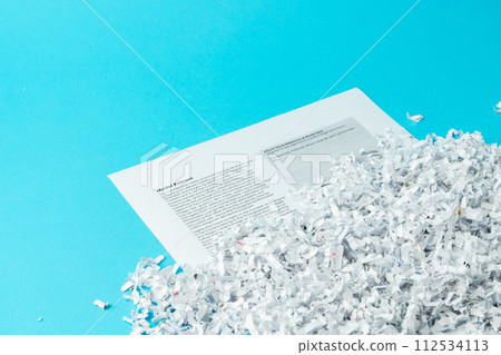 Shredded paper pieces on a blue background Shredded paper pieces on a blue background 112534113