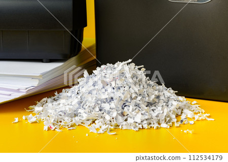 Office paper shredder on yellow studio background Office paper shredder on yellow studio background 112534179