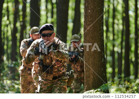 A specialized military antiterrorist unit conducts a covert operation in dense, hazardous woodland, demonstrating precision, discipline, and strategic readiness 112534257