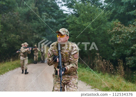A disciplined and specialized military unit, donned in camouflage, strategically patrolling and maintaining control in a high-stakes environment, showcasing their precision, unity, and readiness for A disciplined and specialized military unit, donned in camouflage, strategically patrolling and maintaining control in a high-stakes environment, showcasing their precision, unity, and readiness for 112534376