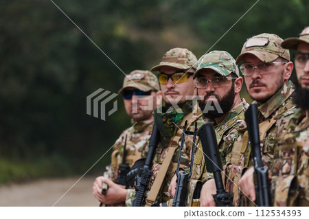 Soldier fighters standing together with guns. Group portrait of US army elite members, private military company servicemen, anti terrorist squad Soldier fighters standing together with guns. Group portrait of US army elite members, private military company servicemen, anti terrorist squad 112534393