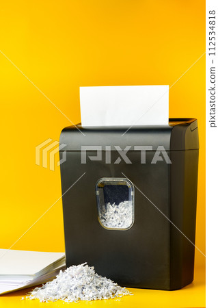 Office paper shredder on yellow studio background 112534818