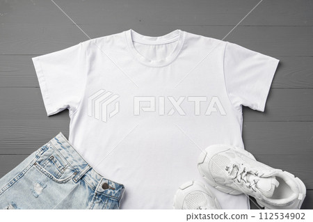 T-shirt, jeans and white sneakers on gray background top view T-shirt, jeans and white sneakers on gray background top view 112534902
