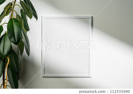 White wooden photo frame with plant leaves on white background 112535090