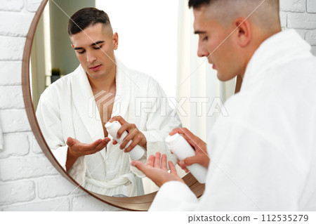 Reflection of a young man shaving in bathroom mirror close up 112535279