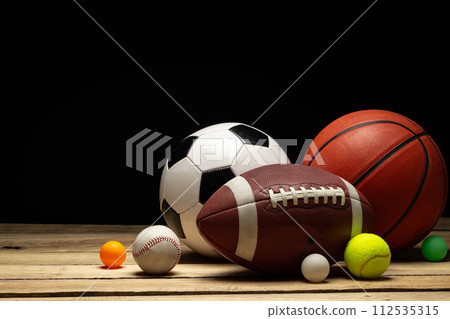 Set of various sport balls on wooden floor on black background Set of various sport balls on wooden floor on black background 112535315